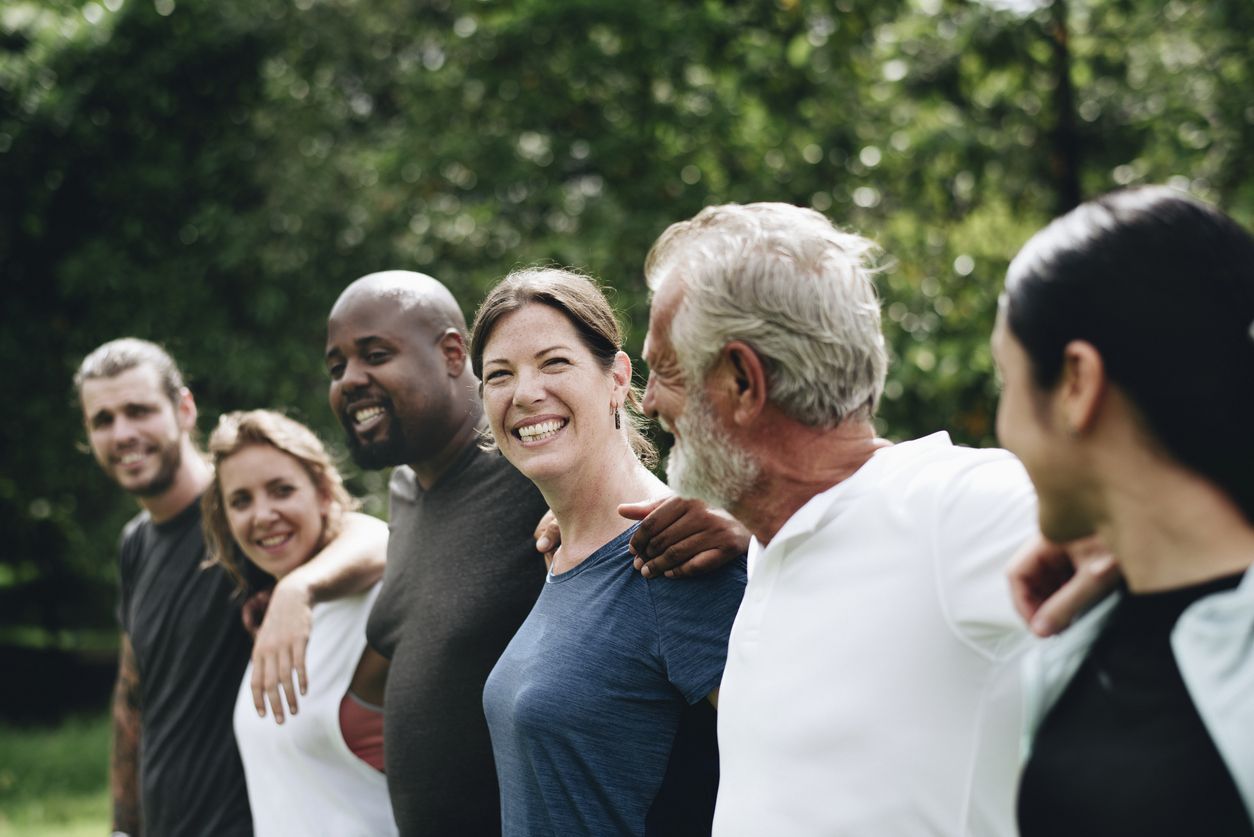 Group of happy people outside in park.